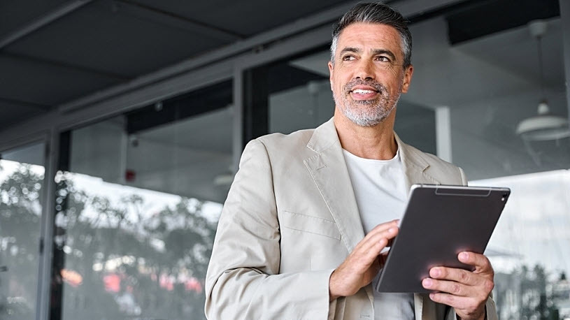smiling mid aged business man holding digital tablet